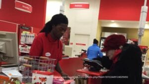 Ishmael Gilbert behind his checkout at Target, helping the elderly customer pay for her items one at a time.