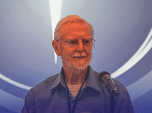 Allen Watson, speaking into a microphone.